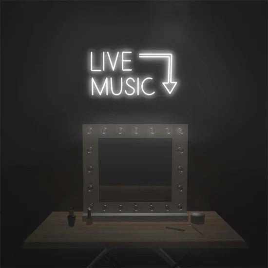 Neon sign reading "LIVE MUSIC" with arrow on dark wall, mounted on plexiglass support above a wooden table.