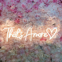 that's amore cuore neon light sign on pink floral wall